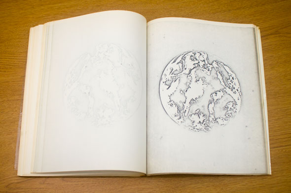 Book spread; left page is blank, right page shows a negative line drawing of the world
