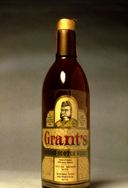A photo of  sealed brown alcohol bottle. The cap is gold and the label of the bottle is a dull gold color. In the middle on the top of the bale is a illustration of an old bearded army man. Underneath the illustration in big red-black gradient text is the product name, "Grant's". In a plain gold banner underneath is "Blended Scotch Whisky" in a slightly smaller thick bold black text. 