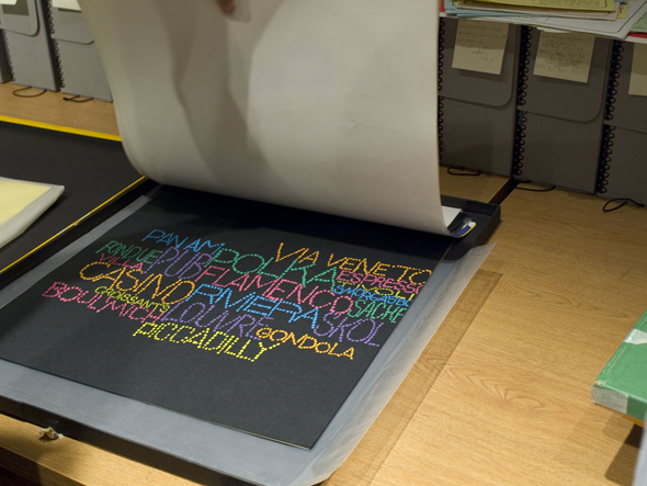 An amazing range of images used in the modular airline terminal displays, in a book on a wooden table.