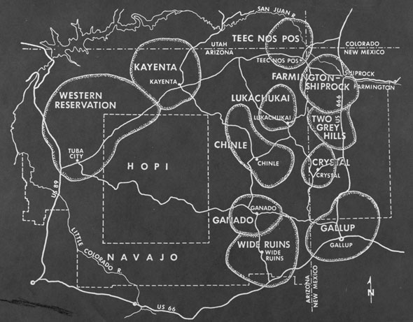 A black paper card with white inscriptions that make up a map, the map is labeled and has a simple compass rose on the bottom right. 
