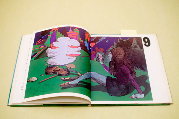 A photo of a open book. The book is opened to page of an illustration of a woman, in a purple skirt and black dress, on the ground next to a violin that has combusted into white smoke. It is night, in the distance there is a colorful purple and orange city emitting dark smoke. The woman is near a forest and the ground bright lime green. 
