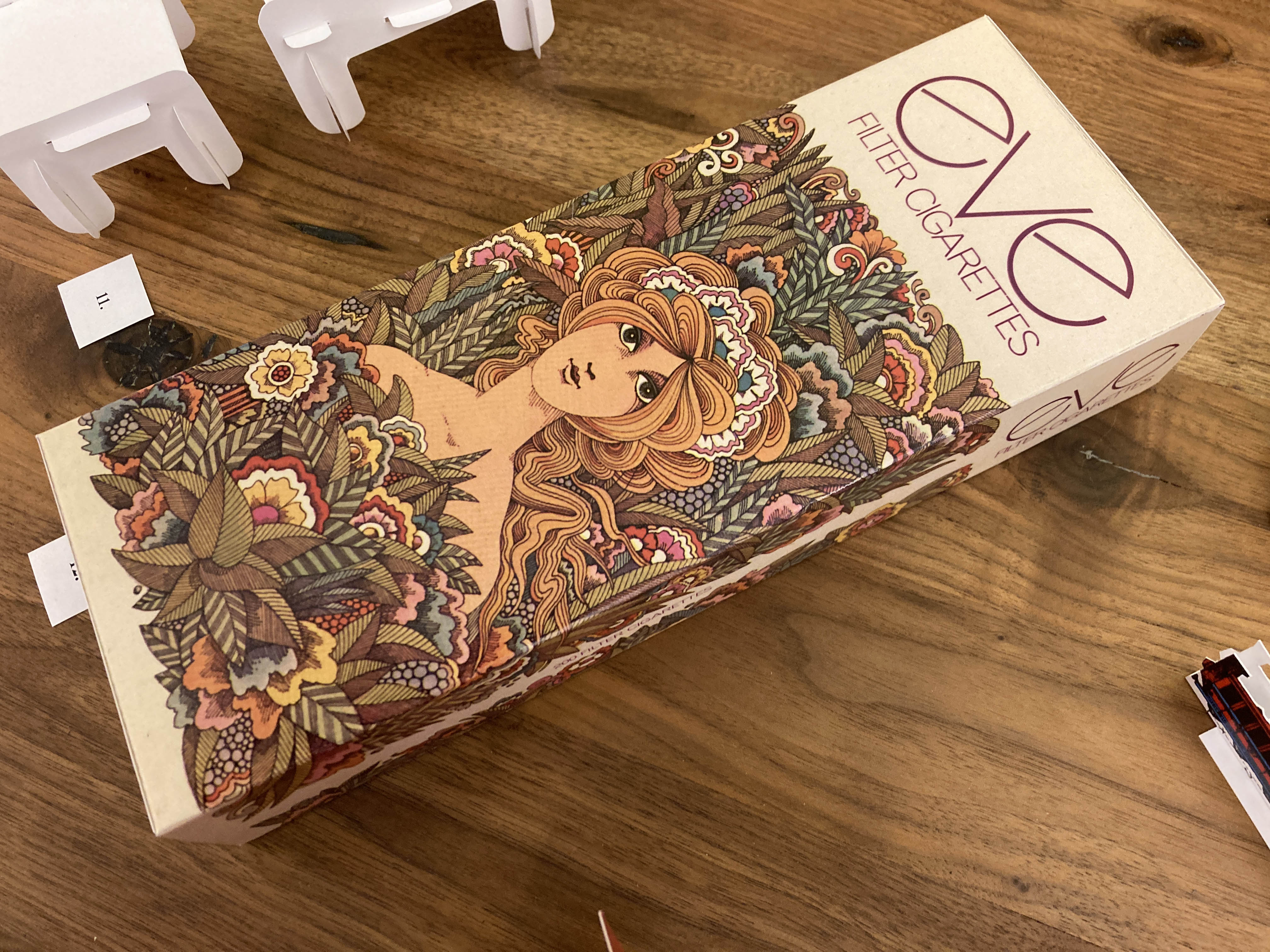 a long cigarette carton with a psychedelic style image of the Biblical Eve in a garden