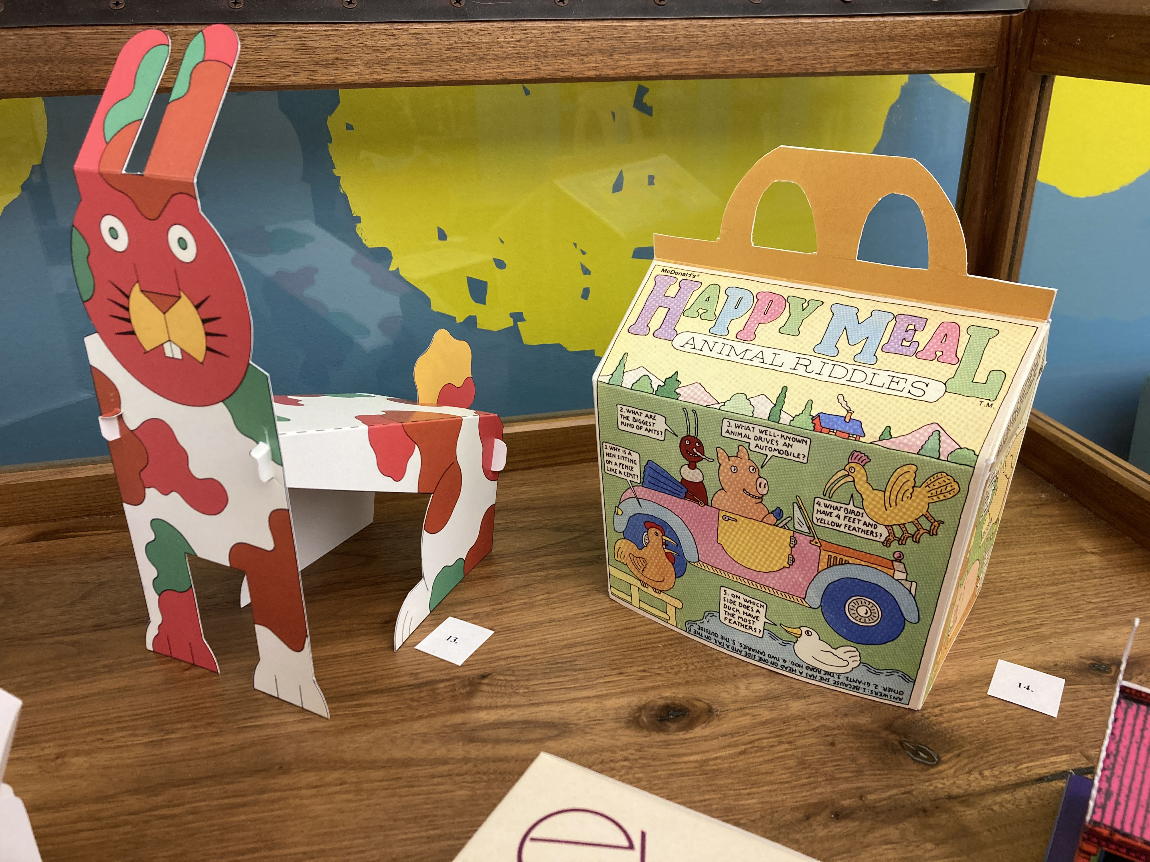 a rabbit made of brightly colored cutout paper and a happy meal box with animal cartoons
