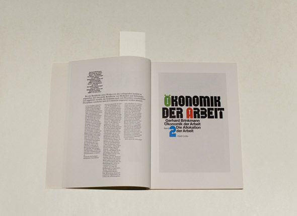 Book spread on white table; Green, red blue and black block text on white