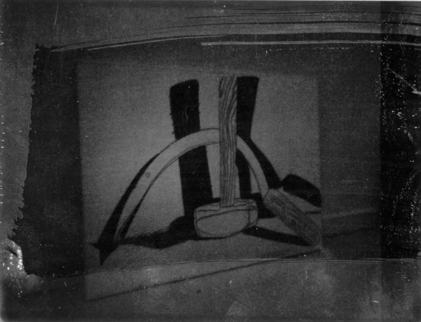 A dark photo of the a huge canvas with a different version of the mallet and sickle. The photo has a wide smear going across the photo making that area darker. 