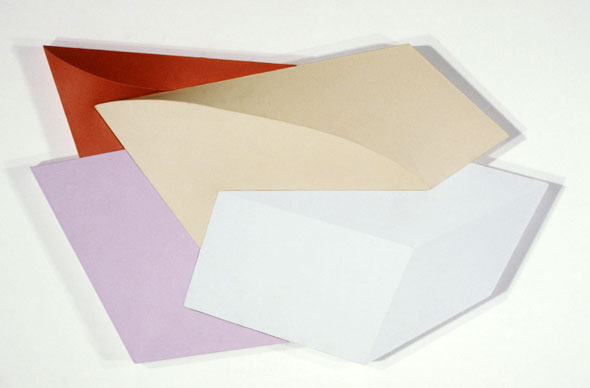 A photograph of a non-rectilinear canvas with painting of different differently colored shapes.