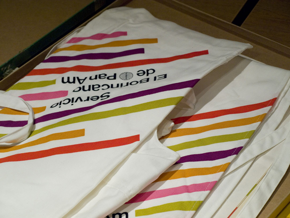 A suite of striped Pan Am aprons; they have colorful, diagonal stripes against white fabric