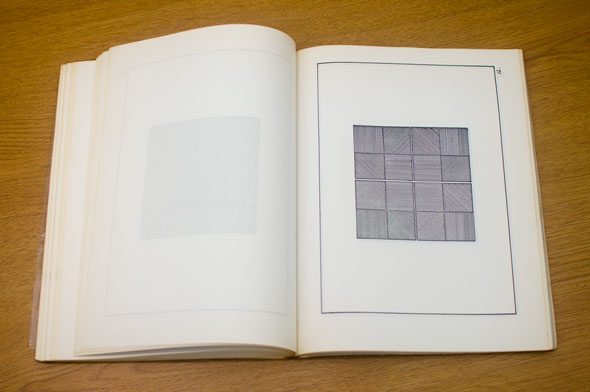 Book spread; left page is blank, right page shows a grey grid inside a box