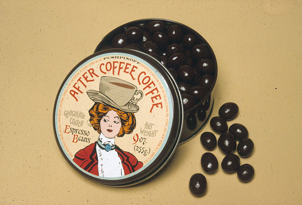 Tin containing espresso beans; lid is an illustration of a redheaded 19th century woman with a coffee cup shaped hat