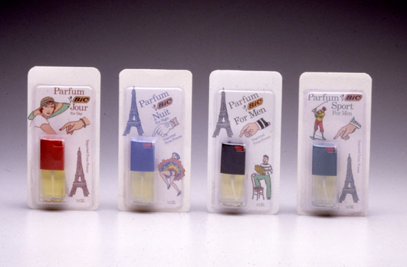 A photo of 4 packages of tiny perfume bottles. All packages have a white background with 3 small illustrations surrounding the perfume. They all have an Eiffel tower, a hand and a drawing that corresponds to the perfume's targeted audience (i.e. a woman's hand for the woman's perfume, a man's hand for the men perfume, a golfer for the sport perfume, etc)