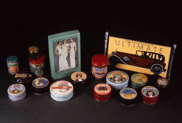 Photograph of the full line of Pushpinoff Sweets, including various colorful tins and a chocolate bar with an automobile on it. 