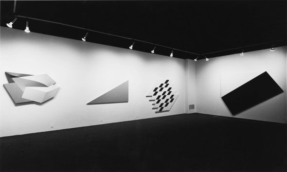 Black and white photos of gallery installation of geometric paintings.