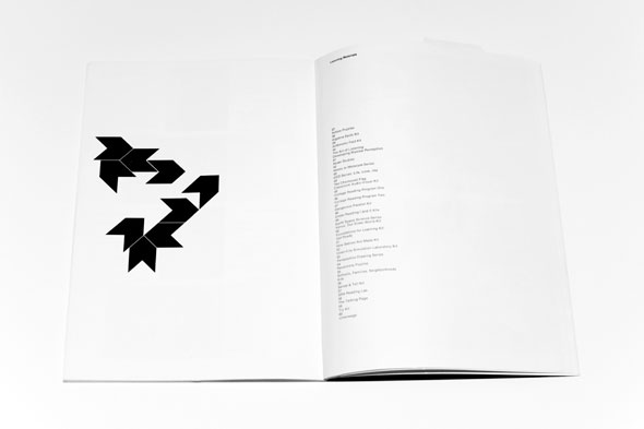 Book spread; left page contains black geometric shapes, right page a column of text