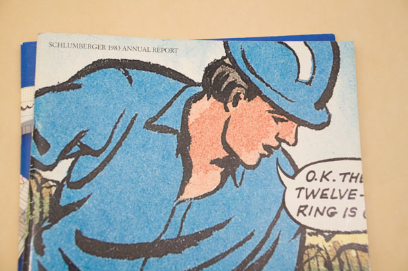 A photo of the cover of an annual report. The cover is water illustration of a working man with a blue hardhat on. He have a sky blue shirt on and has a speech bubble that goes off the page. The man is outlined with thick black ink. 