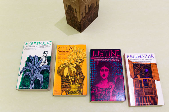 A photo of 4 books. From left to right; "Mountolive", "Clea", "Justine", and "Balthazar". Each book cover has the title on the top in thin text, the color of text correspond to the colors used on their covers. Each book has vibrant saturated colors and sketchy drawings that emphasizes the details. 