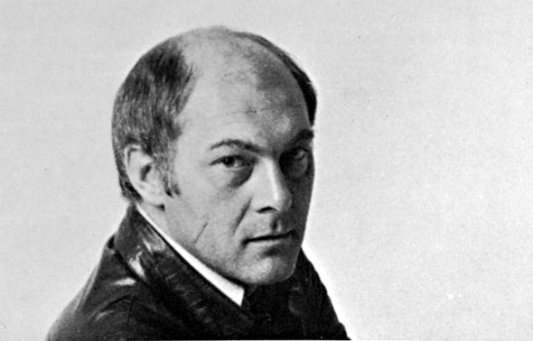 Black and white photograph of a balding man looking into the camera