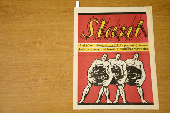 A front cover of a news paper. On a red background three white muscled men each carry a heavy machine. They struggle carrying and slant a bit to the right. Above them in yellow cursive text is the titles of the news paper," Slant". The Title has arrows and arrows on each letter, it's designed to look like a how-to-write-cursive letter. Below the title in a thin yellow background is the definition of, "Slant". "to present (information) in a way that favors a particular viewpoint".