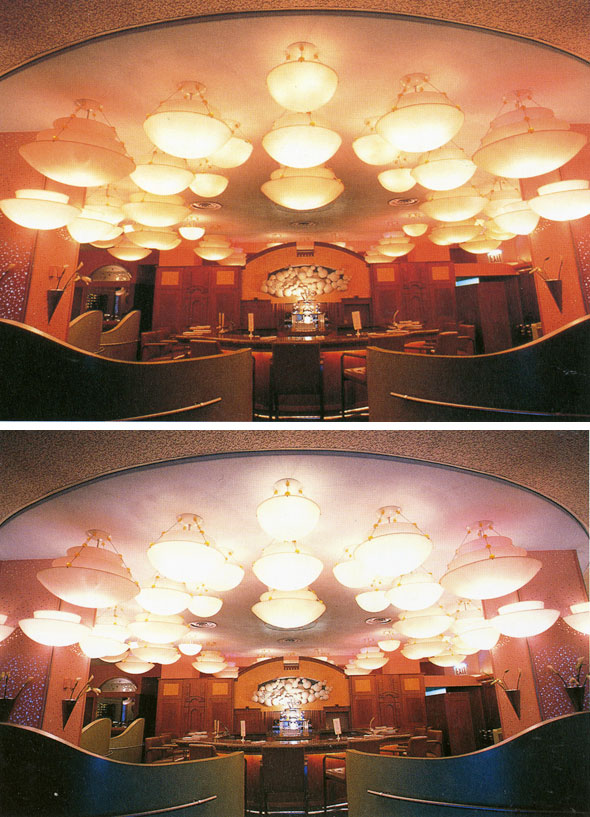 A photo of the ceiling in a restaurant. There are a clutter of dome-like lights hanging. The lights are bright white.