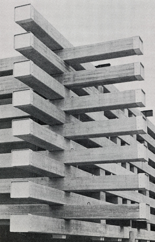A black and white image of a column-like building with protruding corners.