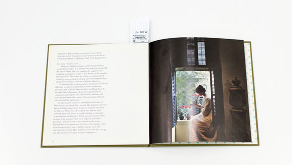 An open book displaying an indoor image of a Eastern woman sitting by a small balcony.