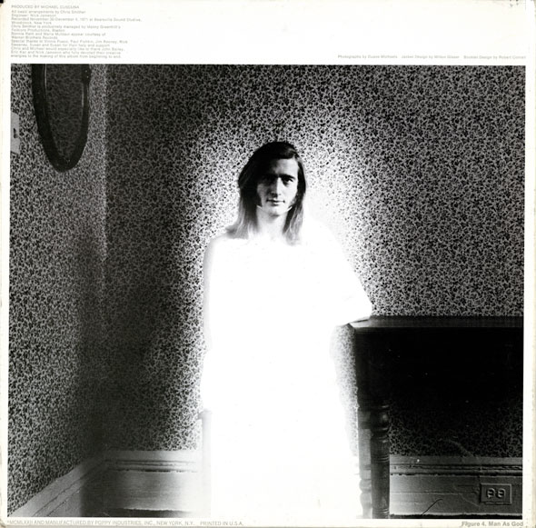 Black and white photo of A longhaired man sits by a piano is a wallpapered room; his body is engulfed in bright white light. It's the same room and man as the previous pictures.