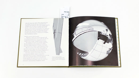 An opened book displaying a black and white circular, fish-eye lens image of a man in an office.