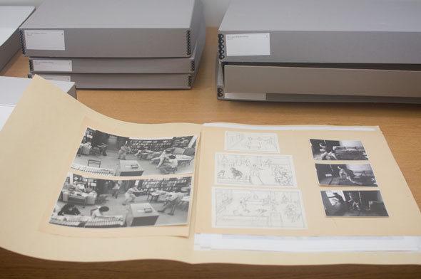 A photo of a folder wide open. Inside on the left are 2 monochrome printed pictures. Next to it are drawings of the printed picture on a small paper. On the right are 3 smaller printed pictures of a person.
