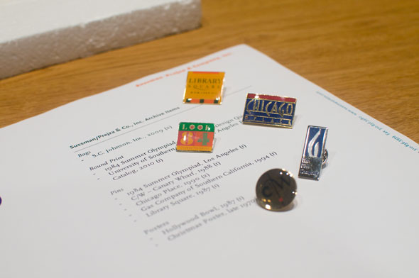 A photo of a collection of colorful enamel pins on a table.