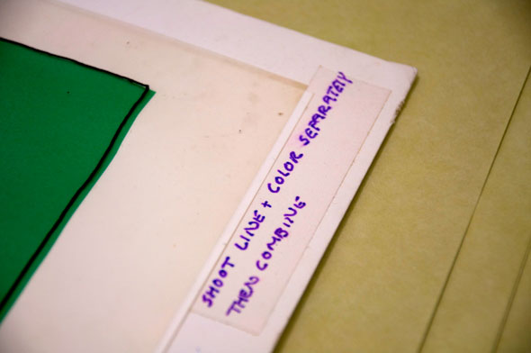 A close up photo of the bottom of the elephant illustration. The illustration lays on a thick paper which has a labeled with "Shoot Line and color separately Then combine" written on it. 