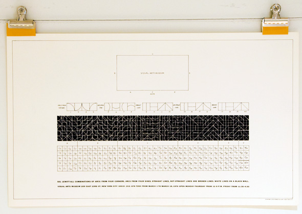 Print, held to board by clips, of a poster with black and white grid blocks on it