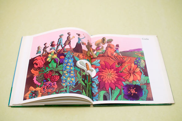 A photo of an opened book. The book is opened to a page of an illustration of line of musicians walking on a field of flowers.  There are 10 people on the line of musicians, some carry an instrument or is holding a kid's hand. The flowers are all different types of flowers, their colors are saturated and colorful.