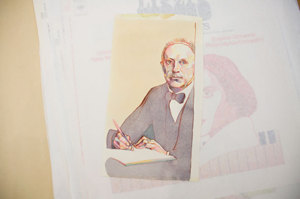 A photo of a watercolor illustration. A man wearing a black and white suite and black bowtie is sitting while writing on a book. The man's skin is not only a plain beige, but also has hints of green, yellow, pink, and blue. 