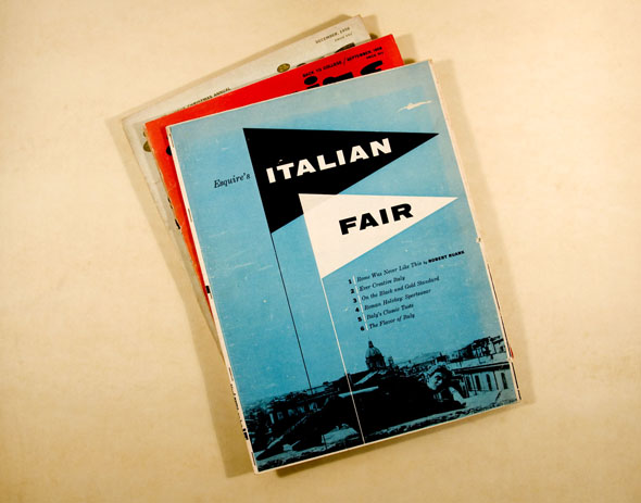Photograph of a stack of three white, red and blue magazines